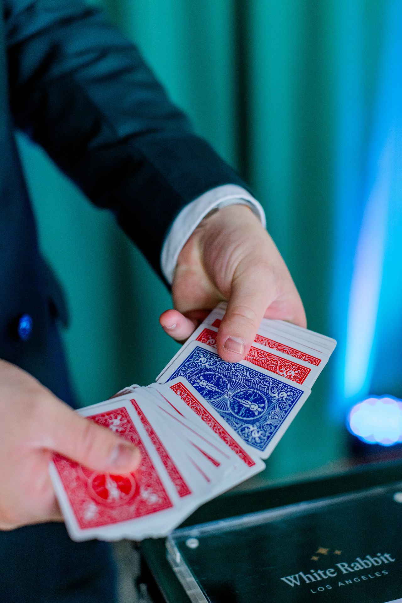Close-up magic with emerald green curtain backdrop at White Rabbit private magic show Los Angeles