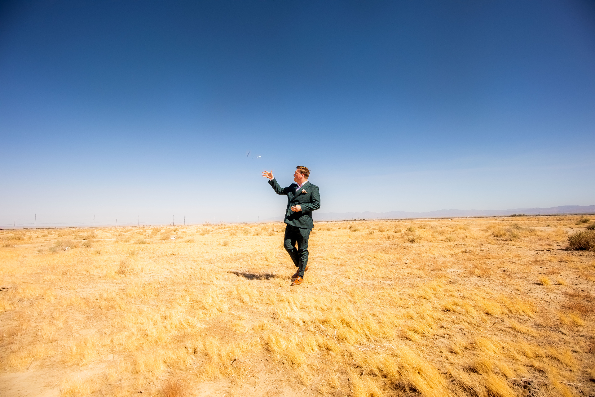 Scott Syme, White Rabbit luxury magician tossing cards in a cinematic desert landscape – private event entertainment in Los Angeles